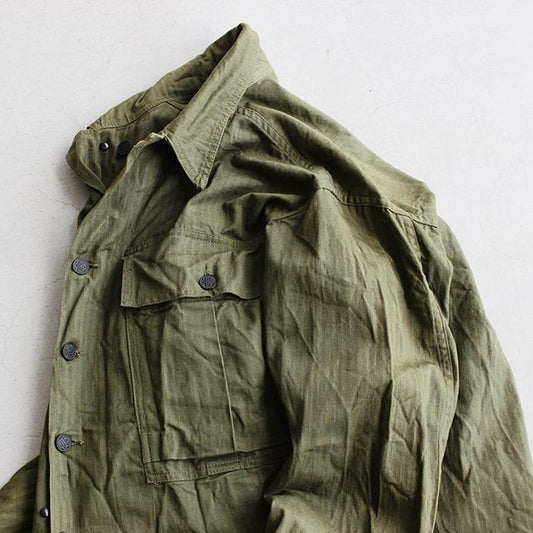 【40s US Army M-43 HBT Jacket】40年代に多様されたHBT(ヘリンボーンツイル)素材が使われたヴィンテージミリタリージャケットが入荷しております。経年変化が素晴らしいHBTや胸元の大きなフラップポケット、13星ボタンなど40sの魅力が詰まった1着です。色褪せた風合いのものが多いアイテムですが。まだまだOliveカラーの残るとても良い状態で入荷しております。状態の良い物をお探しの方にはオススメしたい一品です。